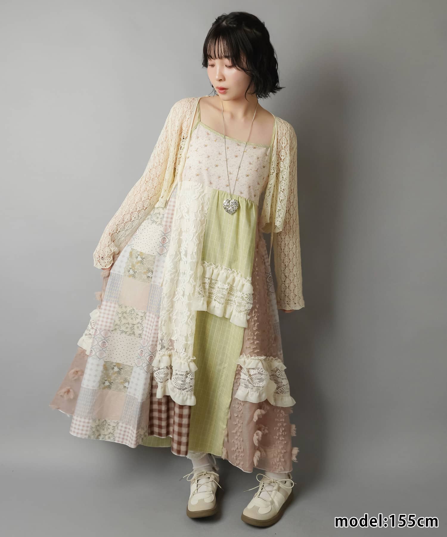 SPINNS Neo Mori Girl model in patchwork maxi dress with floral and checked panels, cream lace cardigan and ruffled trims